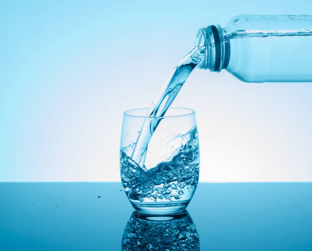 istock Bottle with creative splashing water in the glass 672186172