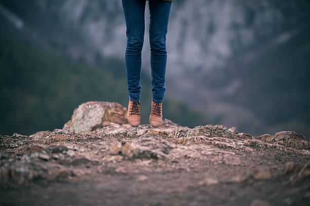 istock Low Section Of Person In Mid-Air Over Field 672195925