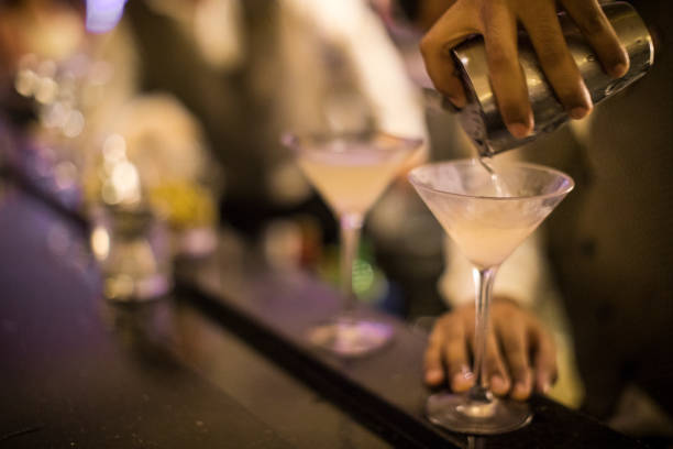 汚れマティーニをグラスに注いでパナマ バーテンダーの手。 - martini martini glass dirty martini olive ストックフォトと画像