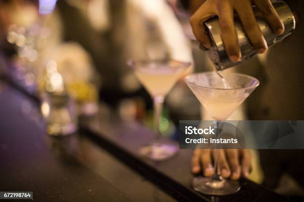 Hands Of A Panamanian Bartender Pouring Dirty Martini Into A Glass Stock Photo - Download Image Now