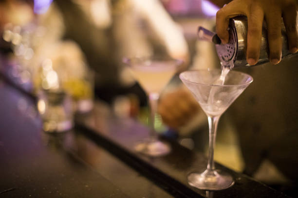 汚れマティーニをグラスに注いでパナマ バーテンダーの手。 - martini martini glass dirty martini olive ストックフォトと画像