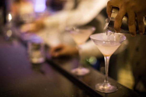 manos de un camarero panameño verter dirty martini en un vaso. - martini martini glass dirty martini olive fotografías e imágenes de stock