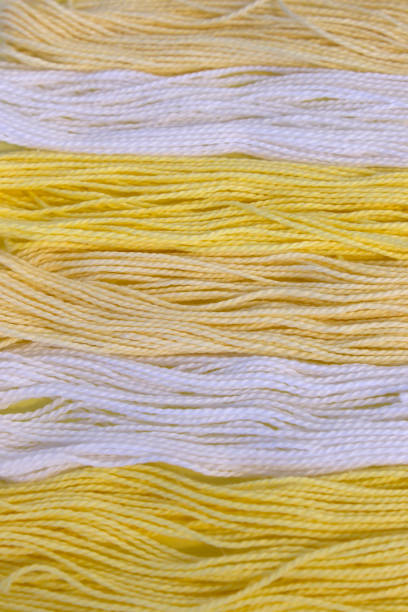 istock Pastel Yellow and White cotton Embroidery threads background 672219778