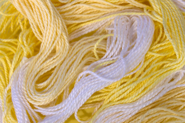 istock Pastel Yellow and White cotton Embroidery threads background 672219796