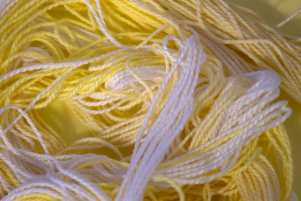 istock Pastel Yellow and White cotton Embroidery threads background 672219804