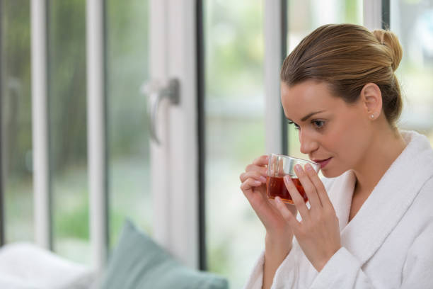 istock beautiful woman drinking tea in relaxation room 672225834
