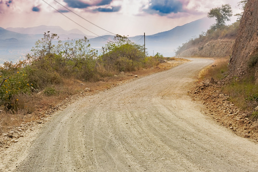 Dirt road to San Luis Jilotepeque in Guatemala and the mountains at the background.