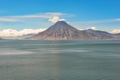 Picturesque landscape view of a volcano on the far side of Lake Atitlan from Panajachel, Guatemala.