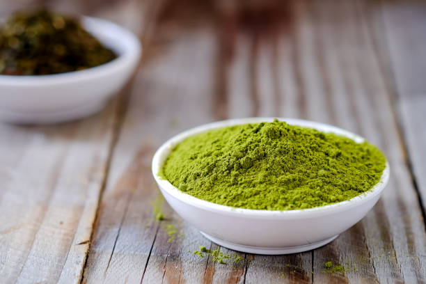 istock Green tea powder with dried tea in white cup. 672233176