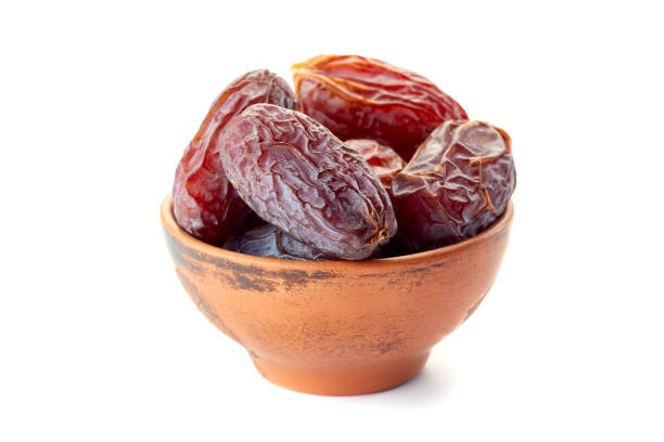 istock Ceramic bowl with date-fruits on white 672233196