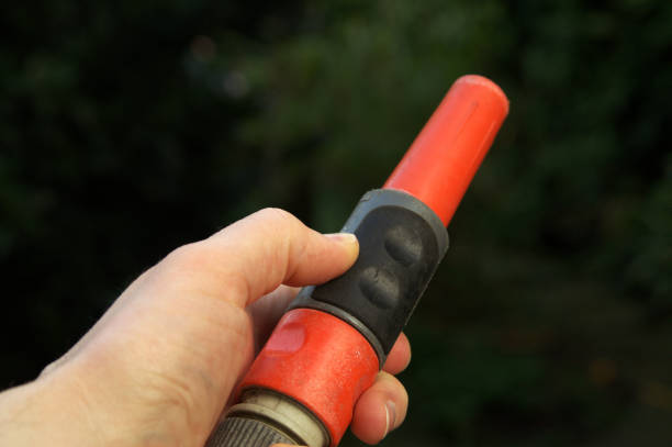 istock Hand on garden hose nozzle 672235916
