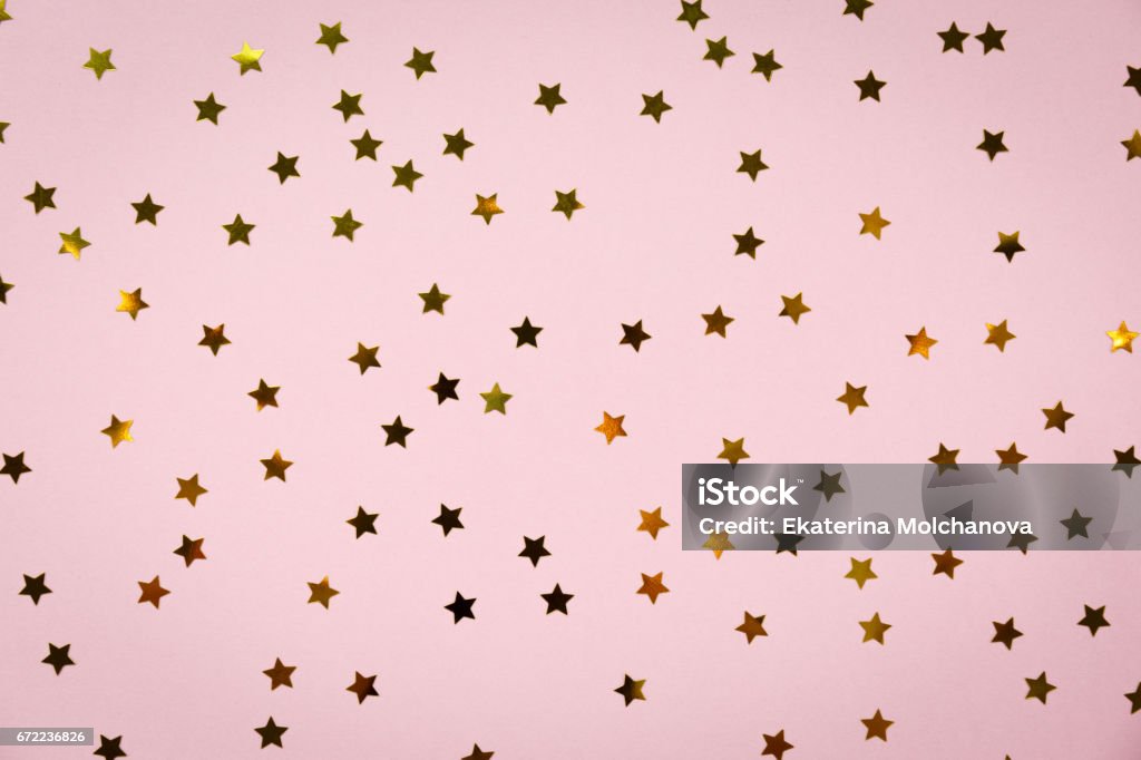 Golden star sprinkles on pink. Festive holiday background. Celebration concept Golden star sprinkles on pink. Festive holiday background. Celebration concept. Top view, flat lay. Horizontal Flat Lay Stock Photo