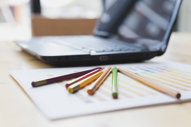 istock graphic designer desk table with computer, crayon and color guide palette swatches 672237182