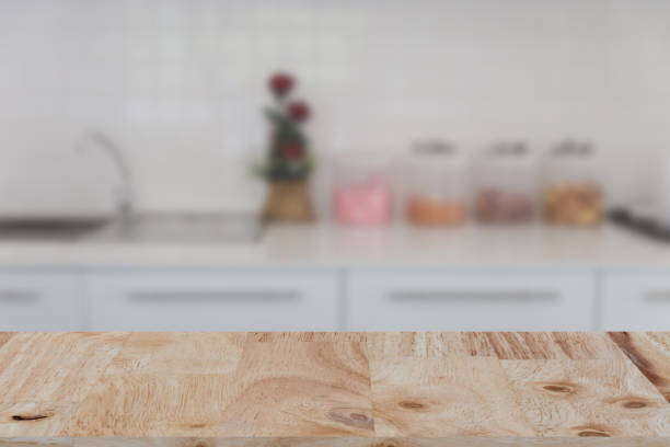istock blurred white kitchen bench interior with selected focus wood table for montage or display your product 672237202