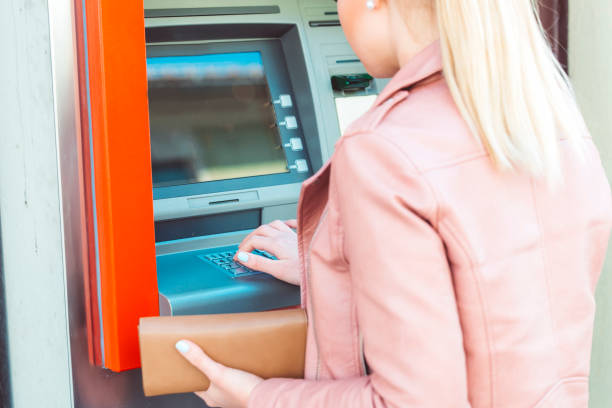 istock Young woman withdrawing money from ATM 672246606