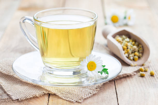 istock Chamomile tea in glass cup, chamomile flowers and dry tea on background, horizontal 672247870
