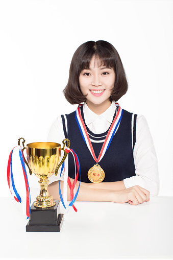 chinese female student holding a golden trophy on white background