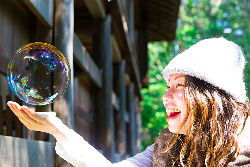 Happy woman playing with the big bubble