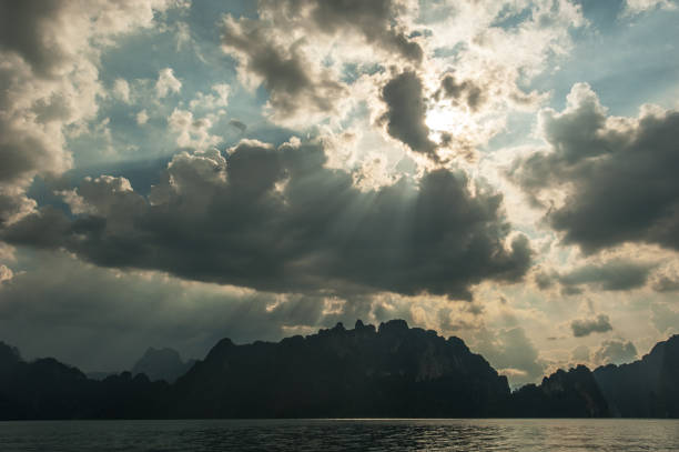 istock Beautiful sun rays through the clouds over mountains,evening light,Amazing scene at Khao-Sok National Park of Thailand 672272624