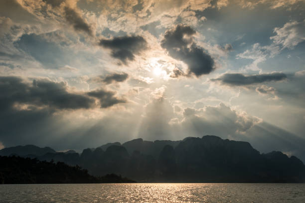 istock Beautiful sun rays through the clouds over mountains,evening light,Amazing scene at Khao-Sok National Park of Thailand 672272650