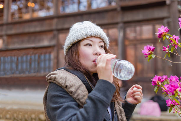 istock Young woman drinking water from the bottle 672275528