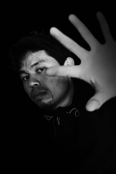 istock man stretching out hand to open something with fear 672278734