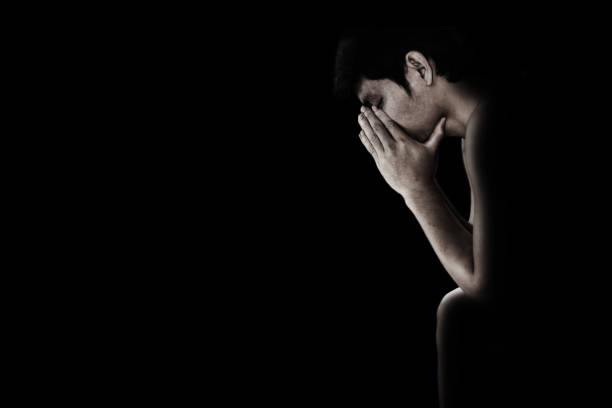 istock depressed and hopeless man alone in the dark 672281822