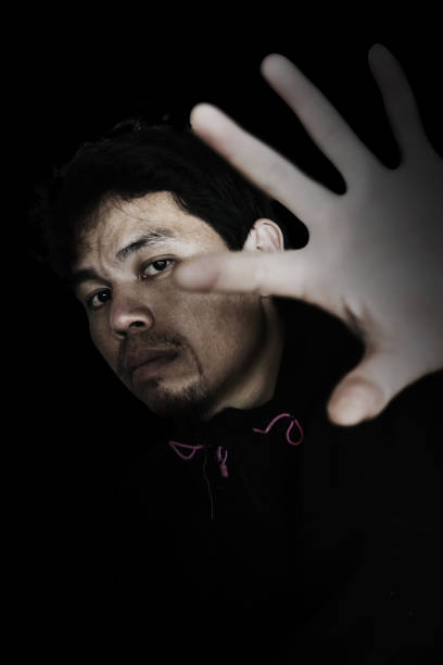 istock man stretching out hand to open something with fear 672284216