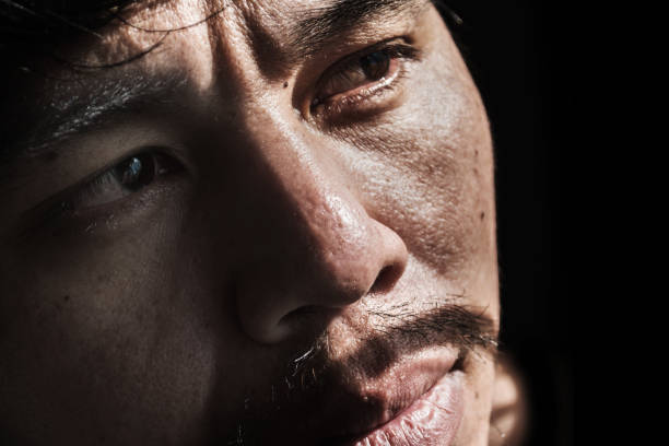 istock face of depressed and hopeless man on black 672284302
