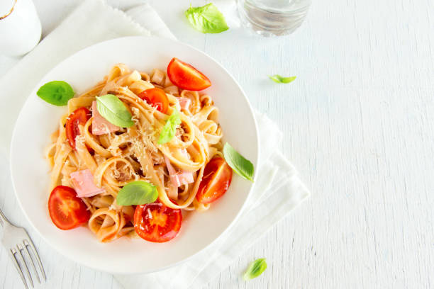 istock Tagliatelle pasta with ham, tomato sauce 672285006
