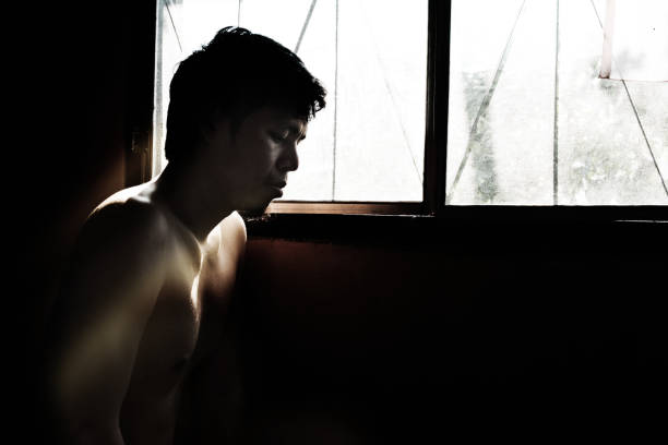 istock depressed and hopeless man alone in the room with window 672285212
