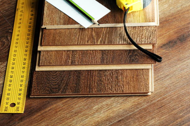 istock Laminate floor planks and tools on wooden background 672287392