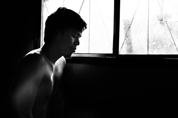 istock depressed and hopeless man alone in the room with window 672287486