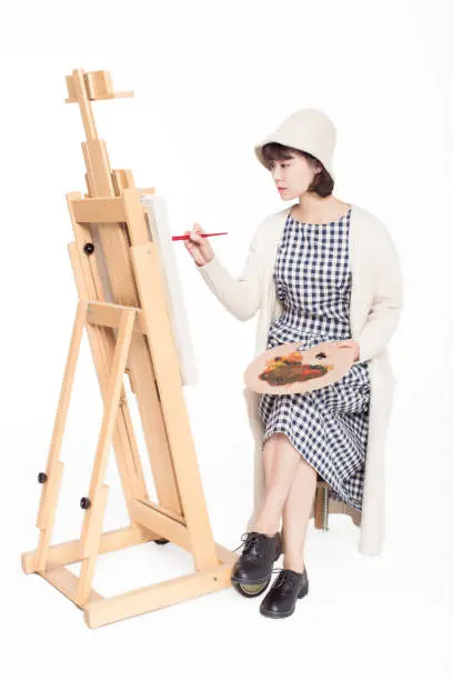 chinese painter beautiful girl, sitting in front sketchpad, holding  palette