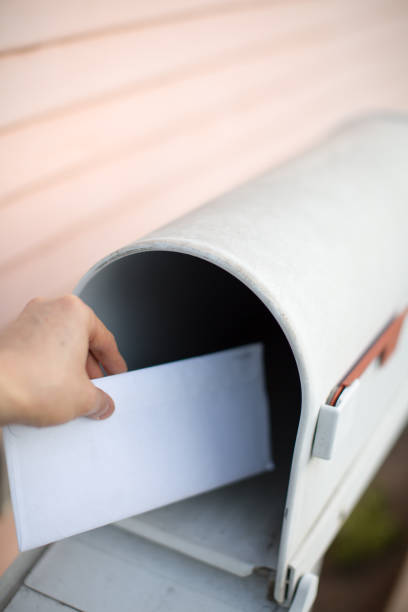 istock Person receiving a letter and getting from mailbox 672304970