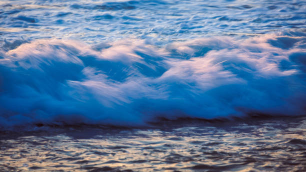 istock Sea wave on the beach at sunset 672305254