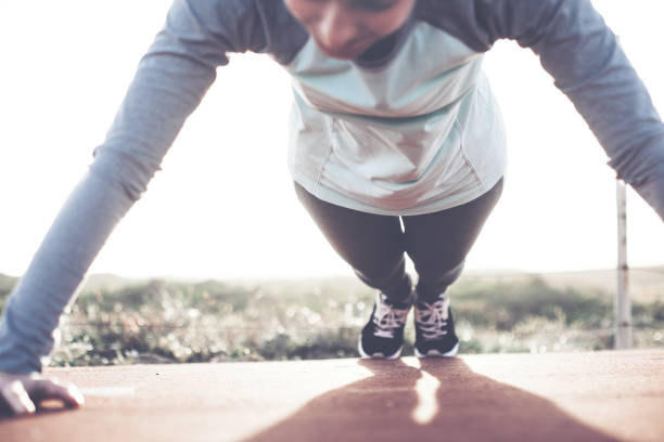 istock Woman athlete doing push-ups exercise outdoors 672305332