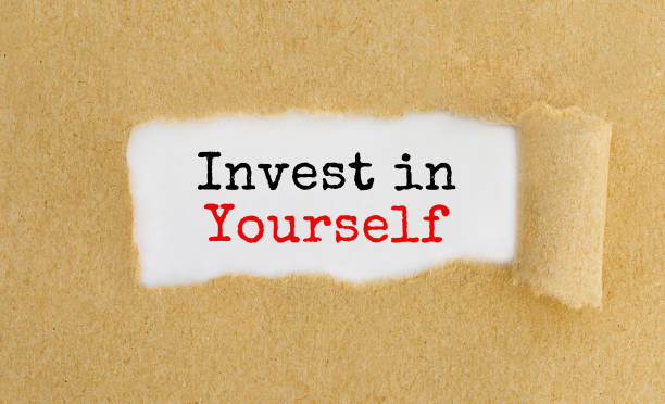istock Text Invest in Yourself appearing behind ripped brown paper. 672308532