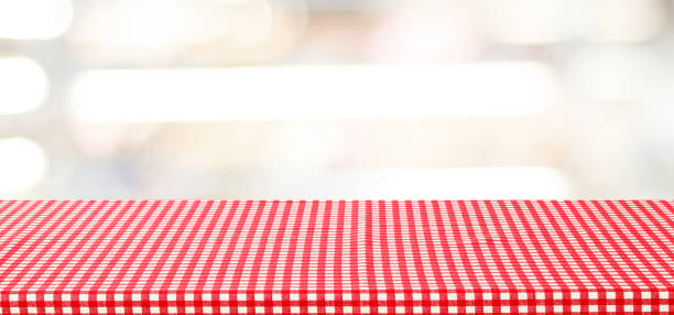 istock Empty table with red check tablecloth over blurred store with bokeh background banner, product display montage 672309978