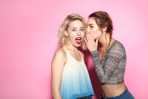 istock Two trendy girl exchanging news 672310432