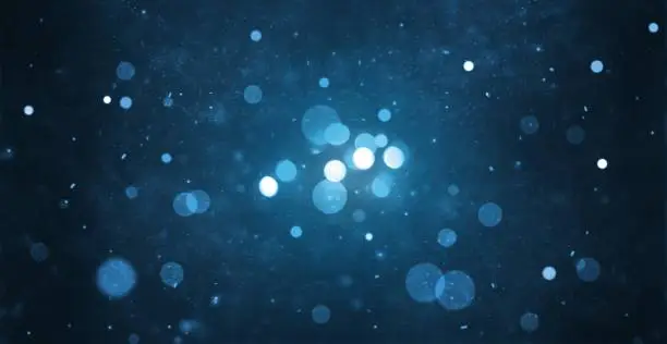 Photo of abstract particle bokeh with dark blue background