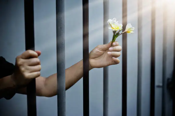 Photo of woman prisoner in prison with white flowers