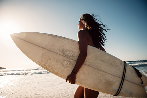 Dark skin girl surfer went surfing.