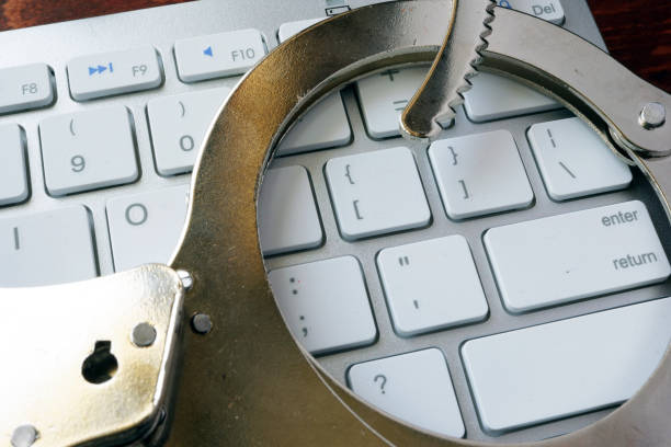 istock Online crime concept. Handcuffs on the keyboard. 672313660