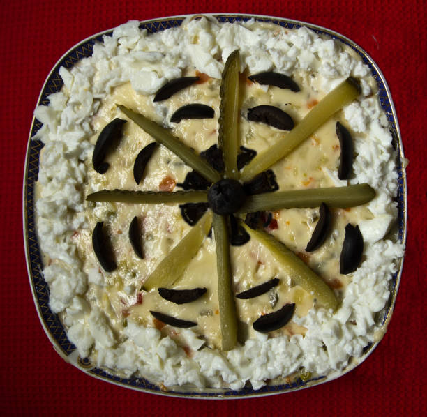 It is a very tasteful Romanian salad made of cooked vegetables, pickled cucumbers, olives and mayonnaise .