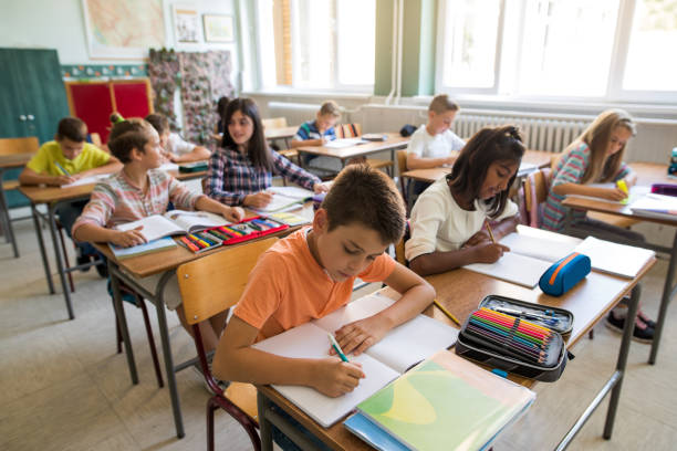 istock Group of school children studying in the classroom. 672317074
