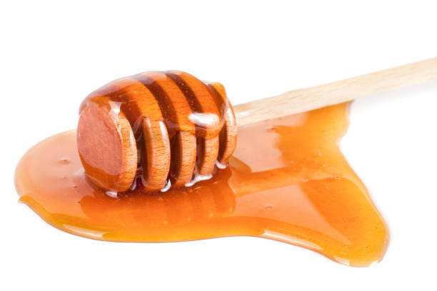 istock Honey stick with flowing honey isolated on white background 672317078