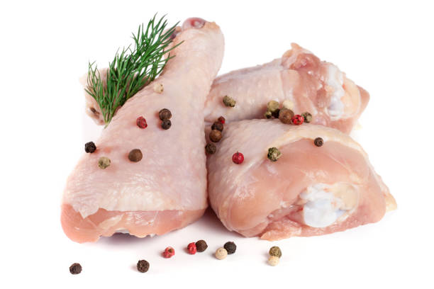 istock Three raw chicken drumsticks with a sprig of dill and peppercorns isolated on white background 672317730