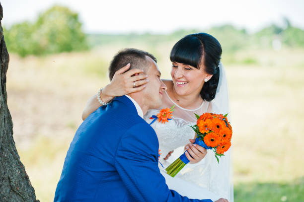 istock sitting wedding couple near tree 672320904