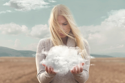 surreal moment , woman holding in her hands a soft cloud